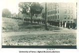 University graduates walking down Washington Street past Engineering Building, The University of Iowa, 1910s