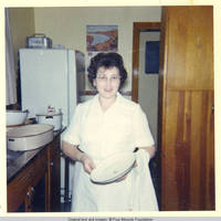 Mildred Hahlen standing in kitchen holding pot lid
