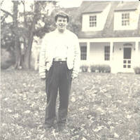 John, Jr. standing behind White house in the Fall