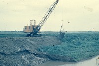 Crane cleaning drainage ditch. 