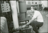 Researcher checking tubing connections, 1973
