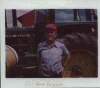 Norm Barker Standing in Front of John Deere Tractor