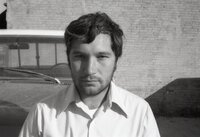 Unidentified man stands in front of trucks