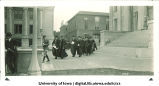 Cadet leading commencement procession in front of Old Capitol west portico, The University of Iowa, June 1928