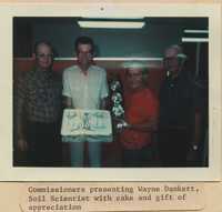 Commissioners presenting Wayne Dankert, Soil Scientist, with a cake and gift of appreciation.