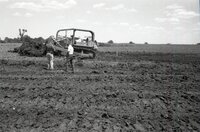 Two men stand in front of earthmoving machine