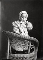 Toddler in fur coat on chair