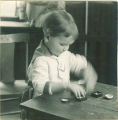 Toddler plays with small boxes, The University of Iowa, 1920s