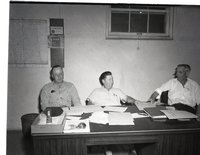 Three Unidentified Men Meet Behind a Desk
