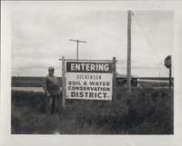 Man Standing by the 'Entering Dickinson Soil & Water Conservation District' Sign.