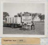 Bob Ingwersen and his Son Stand by the 'Entering' and 'Leaving Dickinson Soil &amp; Water Conservation District' Sign.