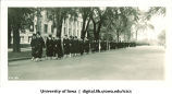 Commencement procession walking east on Jefferson Street past Old Dental Building (right) and Macbride Hall (left), The University of Iowa, June 1927