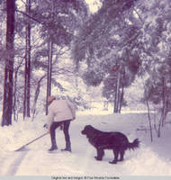 Ainsley Bernard shoveling snow with Sadie, the dog