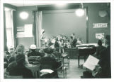 First graders with teacher on stage, The University of Iowa elementary school, March 1958