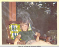 John, Jr. sitting in the smoke on the screened in porch
