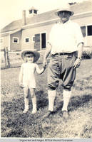 Vidie and George A. Burden behind barn