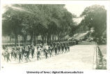 Marching band leading procession down Washington Street, The University of Iowa, 1920s
