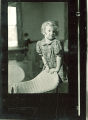 Girl standing behind a wicker chair, The University of Iowa, February 22, 1938