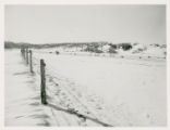 Snowy field with barbed wire fence