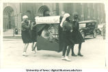 Men in slave costumes carrying litter in Mecca Day parade, The University of Iowa, 1920s