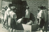 First graders watching a student feed a chicken, The University of Iowa elementary school, May 1932