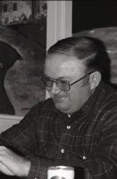 Smiling man in glasses looks down