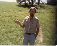 Unidentified Bearded Man Talking in Field with Hand Extended