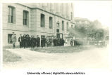 Commencement procession walking past Gilmore Hall, with Macbride Hall in background left and Old Dental Building in background right, The University of Iowa, June 1921