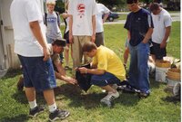1999 Commissioner Jeff Bergman instructs students on planting trees