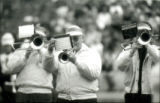 A trumpet player and two trombone players marching in the ISU Alumni Band at Homecoming, 1985