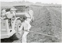 1979  Soil conservation technician talks to man on Caterpillar 613 earthmoving machine
