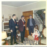 Bob, John, Sr., John, Nili and John, Jr. standing in living room during holidays 