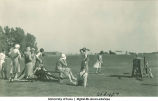 Group watching a young woman drive a golf ball, The University of Iowa, 1920s