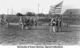 Cadets marching on Iowa Field with American flag, The University of Iowa, 1914