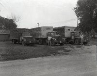 Three trucks with two men standing by them