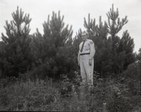 Conservation officer stands by pine trees