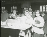 Three individuals enjoying donuts and beverages, 1956
