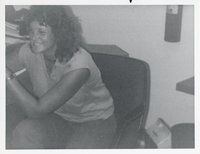 Unidentified Smiling Woman with Curly Hair Sits in Chair