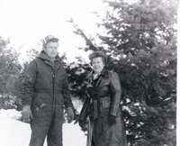 Unidentified man and woman standing near evergreen tree
