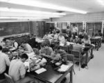 Botany students looking through microscopes and taking notes in classroom in Bessey Hall, 1968