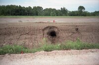 Hole in dirt wall by road