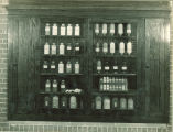 Cabinet of labeled bottles of chemistry compounds, The University of Iowa, 1930s