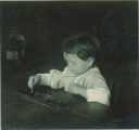 Small child playing with pegboard, The University of Iowa, 1920s