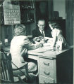 Woman showing pictures to young girl, The University of Iowa, December 1947