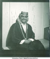 Man dressed in traditional Middle Eastern costume sitting at a party, 1960s