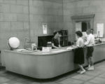 Head reference librarian, Elizabeth Windsor, helping students at the Information Desk, 1962