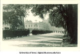 Commencement procession walking south on Clinton Street with Unity Hall partly visible on left, The University of Iowa, June 6, 1922