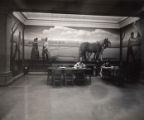 Students studying in front of the Grant Wood mural "Breaking the Prairie."
