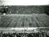 The ISU Marching Band forming the word ""State"" on the football field at Homecoming, 1974