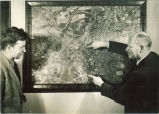Engineering instructor and student with aerial map of Iowa City in engineering laboratory, The University of Iowa, 1939
